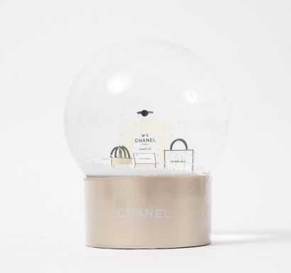 CHANEL Boule à neige à motif d'un flacon de Chanel N°5 entouré de sacs et boîtes...