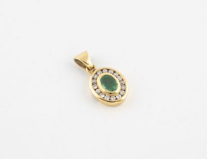 null Yellow gold (750) oval pendant centered on an emerald in a closed setting in...