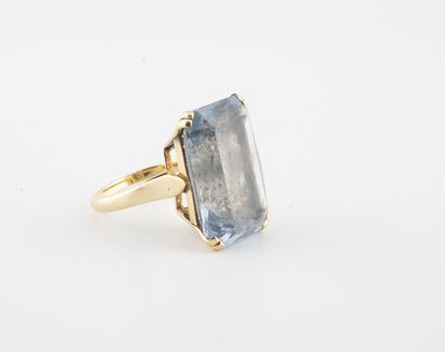 null Yellow gold (750) ring centered on a faceted emerald-cut synthetic blue spinel...