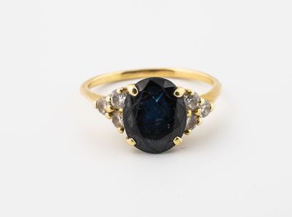 null Yellow gold (750) ring centered on an oval faceted sapphire and set with brilliant-cut...