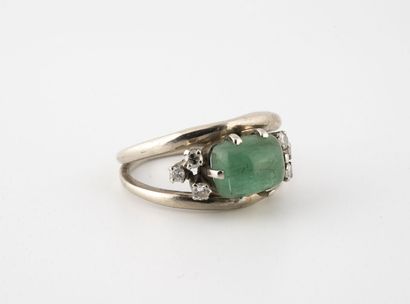 null White gold ring (585) centered on a cabochon emerald in a claw-set setting surrounded...