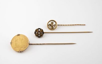 null Three tie pins : 

- one in yellow gold (585) set with a 10 franc gold coin,...