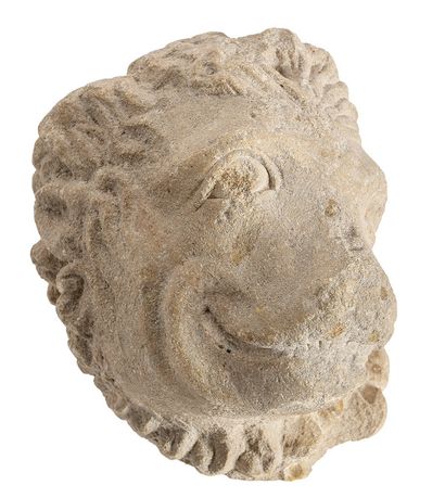  Sculpted limestone lion's head. The head of the animal is turned to the left, presenting...