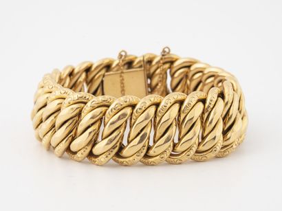 null Large bracelet en or jaune (750) à maille gourmette américaine creuse ciselé....