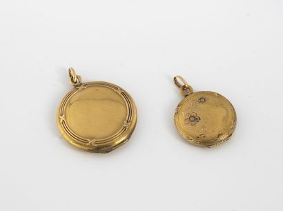 Two round medallion pendants in yellow gold...