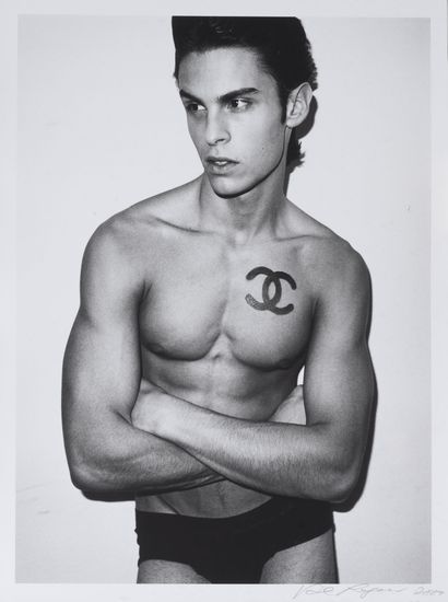 Karl LAGERFELD Baptiste GIABICONI with his arms crossed and the Chanel logo on the...