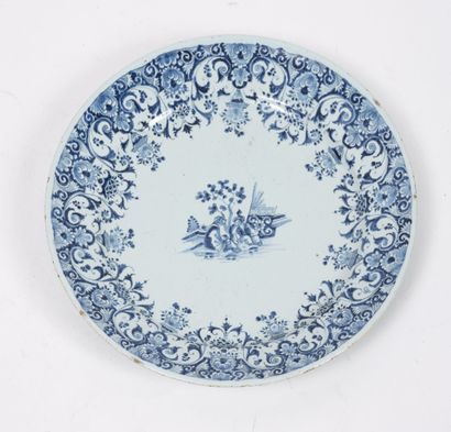 ROUEN, XVIIIème siècle Round earthenware plate decorated in blue monochrome of scrolls...