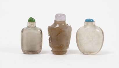 CHINE, XIXème-XXème siècles Three snuff bottles in smoky quartz, brown agate or rock...