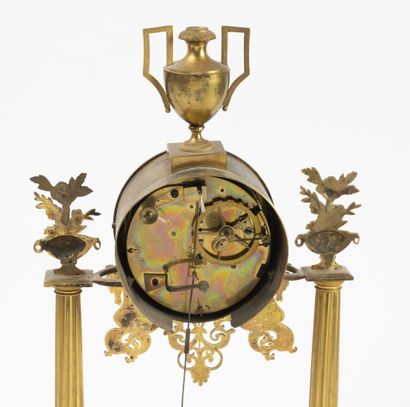null Portico clock in gilded bronze and brass resting on two fluted columns, topped...