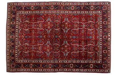 IRAN, Heriz Tapis rectangulaire en laine polychrome à champ rouge à décor de bandes...