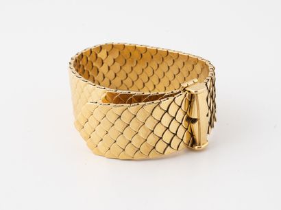 null Beau bracelet ruban articulé à maille écaille en or jaune (750). 

Fermoir clapet....