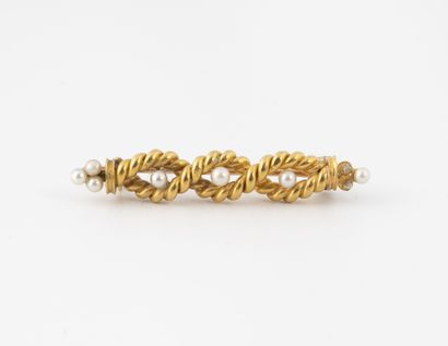 null Petite broche en or jaune (750) formée d'un filin torsadé retenant des perles...