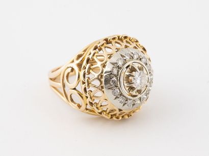 null Yellow and white gold (750) filigree dome ring centered on a brilliant-cut diamond...