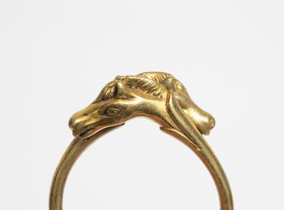 HERMES, Paris Bracelet jonc en métal doré à deux têtes de chevaux affrontées. 
Signé....
