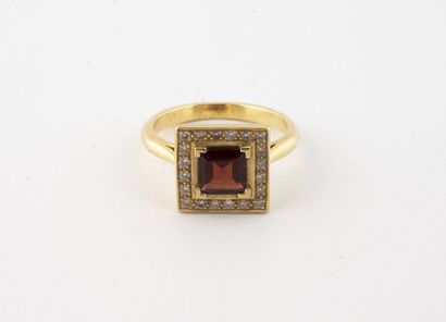 null Yellow gold (750) ring with square top centered on a garnet in a claw setting...