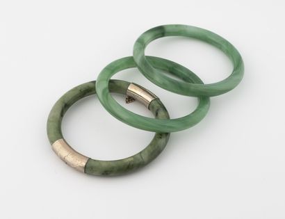 CHINE, XXème siècle Lot of three nephrite and jadeite bracelets, one of which opens...