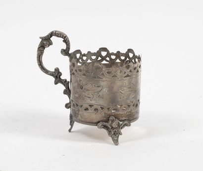 TURQUIE Porte-tasse tripode en argent (min. 800) ajouré à décor de fleurs gravées.
Anse...