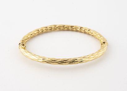 null Bracelet rigide ouvrant en or jaune (750) à décor ciselé de treillis. 
Fermoir...