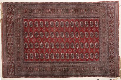 BOUKKHARA Grand tapis en laine polychrome à décor d'un semi de 60 pieds d'éléphants...