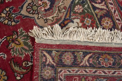IRAN Tapis rectangulaire en laine polychrome formé d'un grand cartouche à champs...