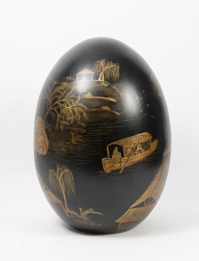 null Ceramic egg painted in gold on a black background, decorated with scenes of...