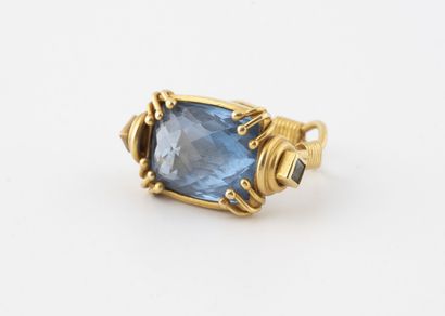 null Yellow gold (750) ring with split ring and clasps holding a faceted synthetic...
