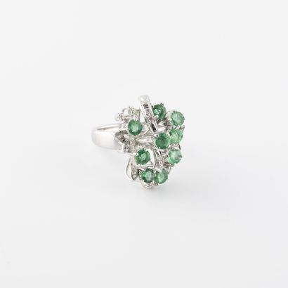 null Silver ring (min. 800) set with emeralds in a raised claw setting and punctuated...