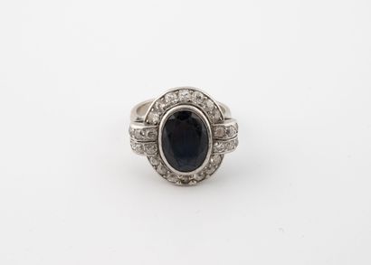 null Ring in white gold (750) centered on a faceted sapphire in a circle of small...