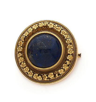 null Broche circulaire en or jaune (750) centrée d'un cabochon de lapis-lazuli baigné...