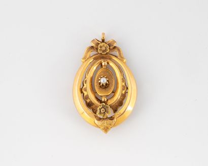 null Petit pendentif médaillon en or deux tons (750) à décor floral ciselé et centrée...
