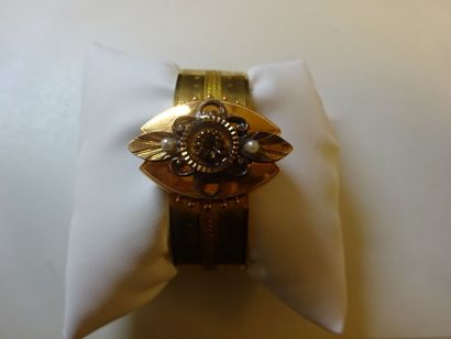 null Bracelet manchette ouvrant en or jaune (750) à décor ciselé ornée d'un motif...