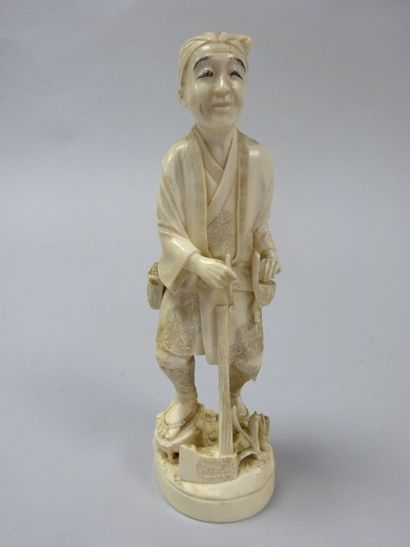 JAPON Okimono en ivoire sculpté (pré-convention) à décor d'un bucheron à la pipe.
Marque...