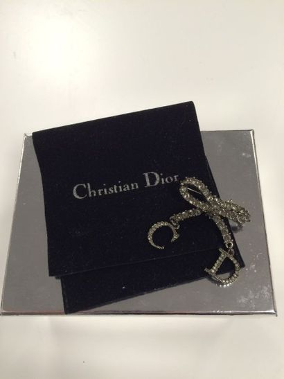 CHRISTIAN DIOR Broche noeud à pendants "C" et "D", en métal et strass.

Signée.

Pochon...