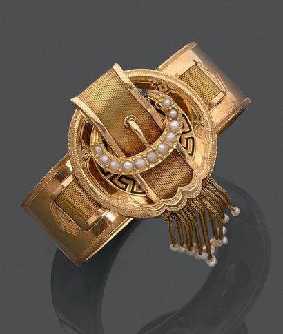 null Demi parure en or jaune (750) comprenant un bracelet rigide ouvrant et une broche...