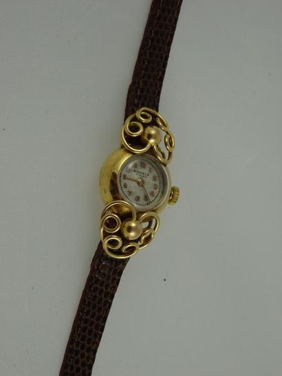 BONHEUR Montre bracelet de dame boiter rond en or jaune (750) épaulé de volutes ajourées...