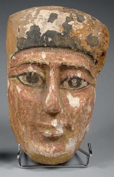 EGYPTE 
Masque-portrait funéraire.
Bois stuqué et peint.
Basse Epoque.
H.: 27,5 cm.
Accidents...