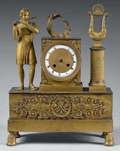 null Pendule borne en bronze et laiton dorés représentant un joueur de flûte et une...
