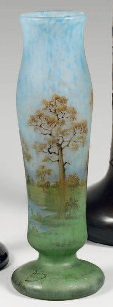 DAUM Vase cylindrique à corps renflé sur piédouche. Epreuve en verre marmoréen bleu...