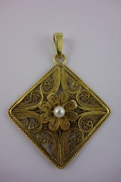 null Pendentif en or jaune (750) à décor de filigranes centré d'une perle de culture....