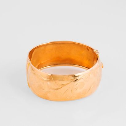 null Bracelet rigide ouvrant en or jaune (750) à décor ciselé de fleurs et feuillages....