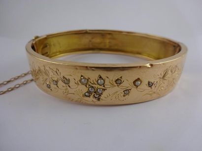 null Bracelet rigide ouvrant en or jaune (750) à décor ciselé de fleurs et feuillages...