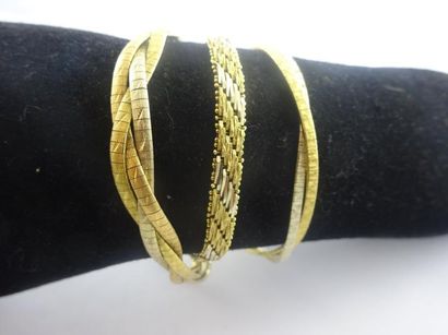 null Lot de trois bracelets en or (750). 

- un ruban à trois filins aplatis croisés...