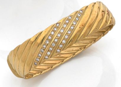 null Bracelet rigide ovale ouvrant en or jaune (750) à décor de godrons, les trois...