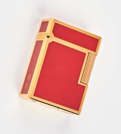 S. T. DUPONT 

Briquet de poche en métal doré et laque rouge, à décor d'idéogrammes...