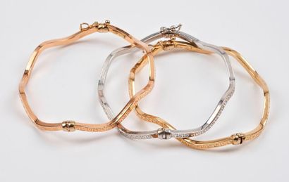 null Trois bracelets joncs ondés, ouvrant, en ors jaune, rose et gris (750) creux...