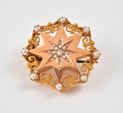 null Broche ronde en or jaune (750) figurant une étoile ornée de diamants taillés...