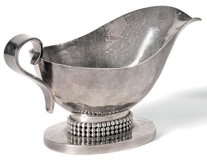 Jean DESPRES (1889-1980) 
Saucière en métal argenté martelé sur piédouche ovale,...