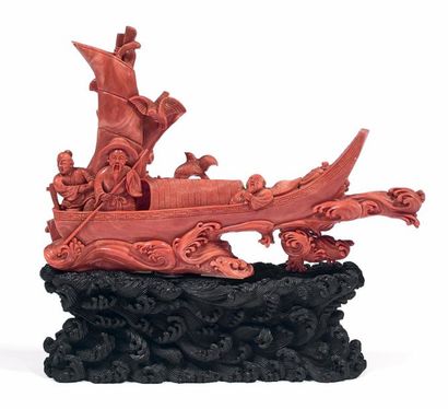 CHINE *Groupe sculpté en corail orangé figurant des personnages sur une barque.
Une...