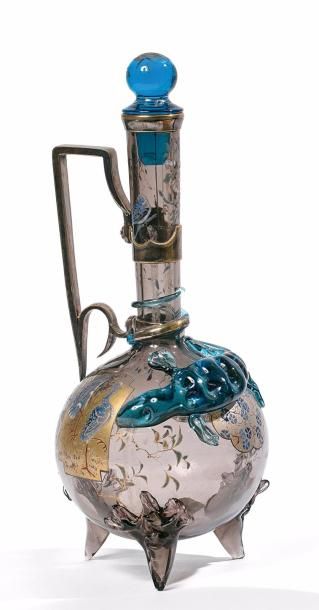 Auguste JEAN (1830-1890) 
Carafe tripode en verre à panse ronde et col droit. L'anse...