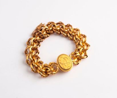 null Bracelet en or jaune (750) à mailles tressées creuses, centré d'un médaillon...